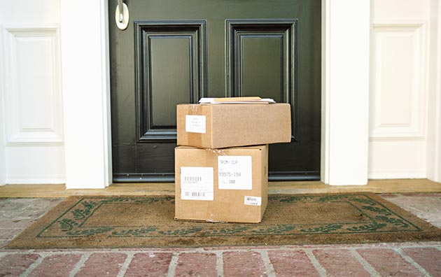 Brown boxes piled in front of a person's front door