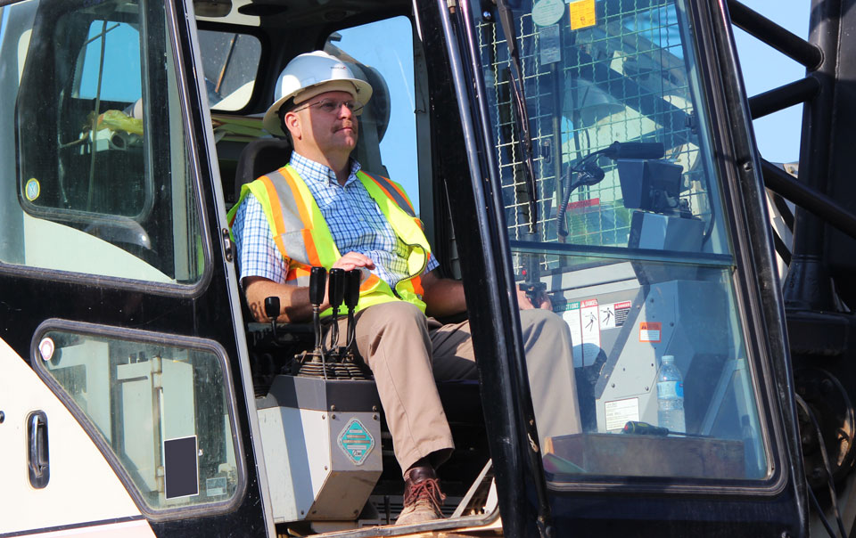 Person sitting in cab of construction vehicle