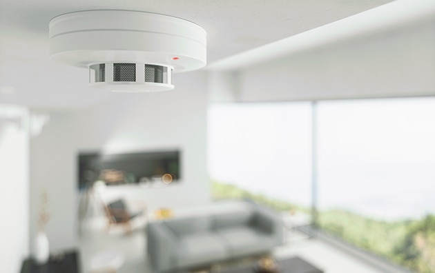 Image of fire detector on ceiling of a home, Does Homeowners Insurance Cover Fire?