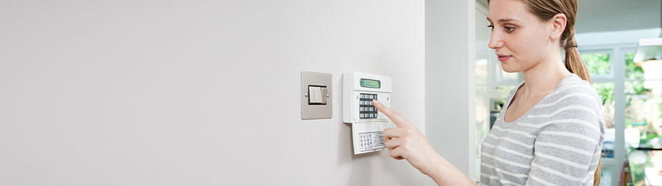 Woman setting home security alarm