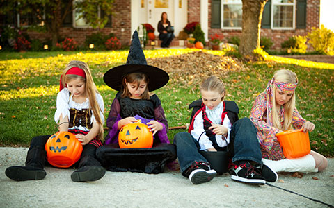 Four kids in Halloween costumes