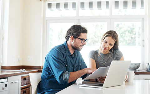 man and woman comparing home and mortgage insurance