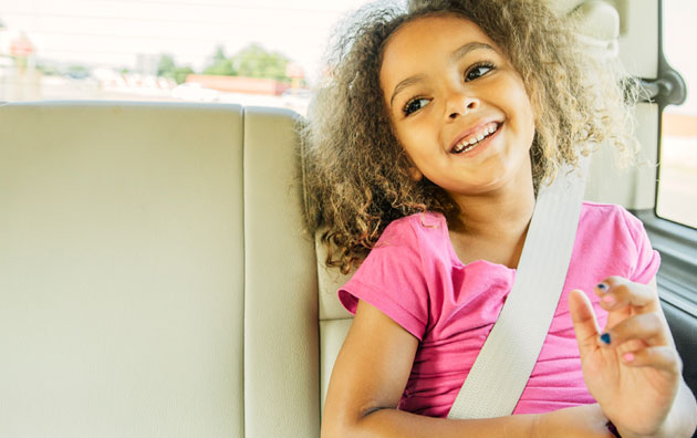 Young passenger sitting safely in the back seat of a car