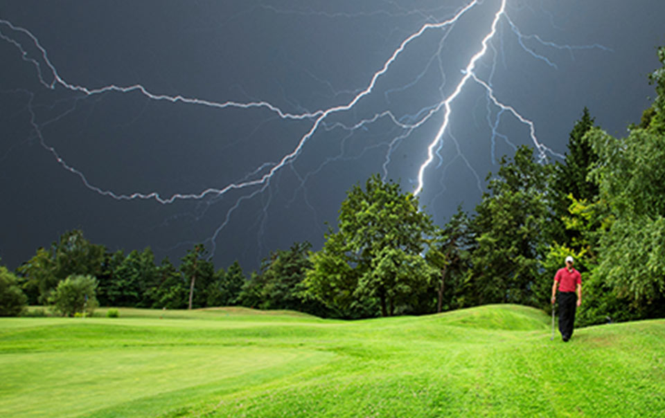 Golfer walking outside during lightning storm