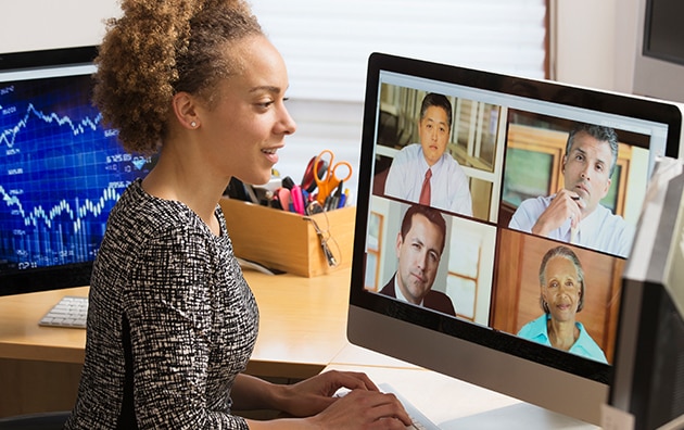 A woman sits at desk at home on a video conference call. Managing Remote Workers During COVID-19