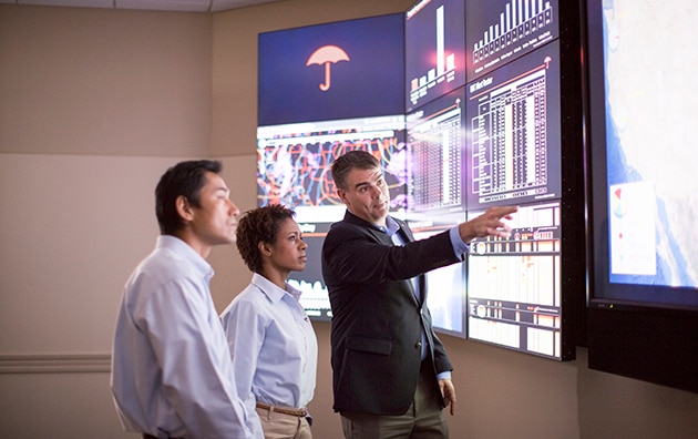 Claim professionals looking at data on large monitors