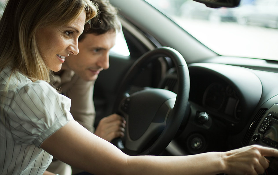 Couple sitting in new car and deciding if should buy a new car