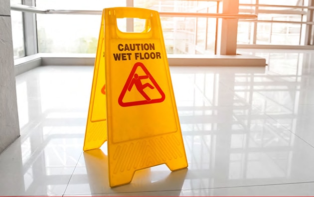 caution wet floor sign in lobby of workplace
