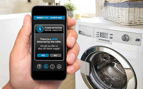 Hand holding smart device in front of washer.