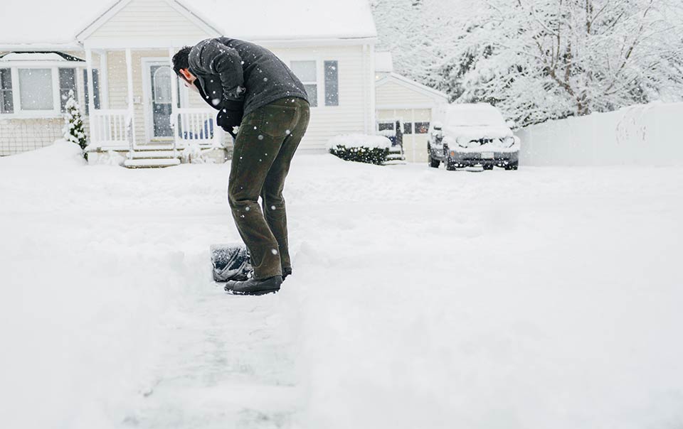 Person shoveling snow outside house