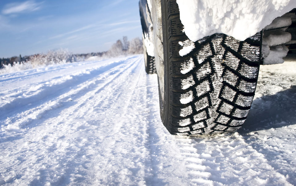 Close-up of snow tires on snow-covered road
