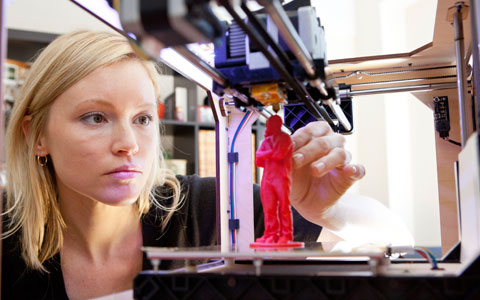 Woman reviewing 3D printed red figurine